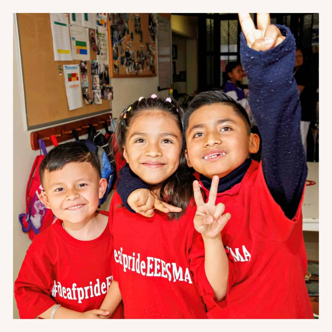 Happy children wearing, smiling and making peace signs indoors, featuring the impact of a SMCF Nonprofit Network Member organization.